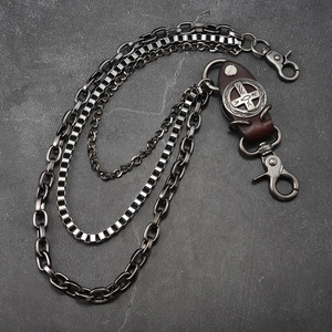 Détail d'une chaîne de portefeuille punk multicouche avec emblème de croix en cuir et fermoir