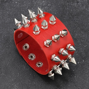 Detail of red leather punk bracelet featuring three rows of silver metal cone spikes