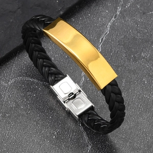 Detalle de pulsera de cuero trenzado negro con placa dorada y cierre de acero