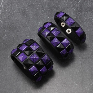 Detailansicht von Punk-Lederarmbändern mit schwarzen und violetten Pyramidennieten