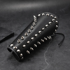 Close-up of black punk leather bracer with silver metal spikes and scale texture