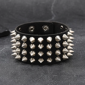 Detail of a black leather punk bracelet featuring four rows of sharp silver metal spikes
