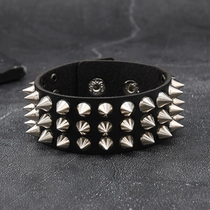 Detailed view of three rows of silver metal spikes on a black leather punk rocker bracelet