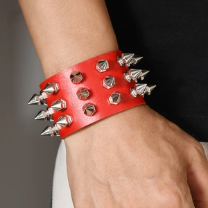 Detail of red punk leather cuff bracelet featuring three rows of silver cone spikes