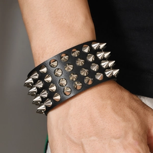 Close-up of black leather punk bracelet with four rows of silver metal spikes on wrist