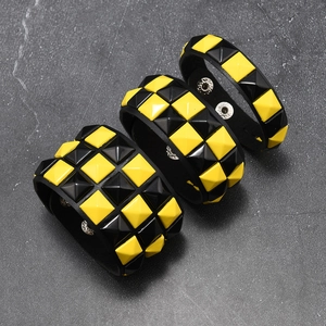 Detailansicht der Punk Lederarmbänder mit gelben und schwarzen Pyramiden-Nieten