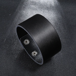Close-up of black cowhide leather bracelet with textured surface and double snap buttons