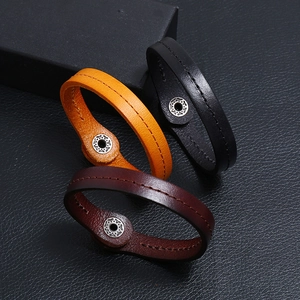Three punk style leather bracelets in yellow, black, and dark red with metal snap buckles