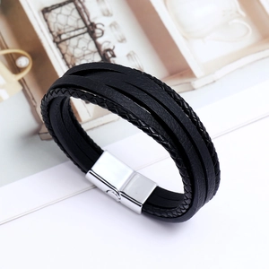 Détail d'un bracelet en cuir tressé multicouche avec un fermoir magnétique poli en argent