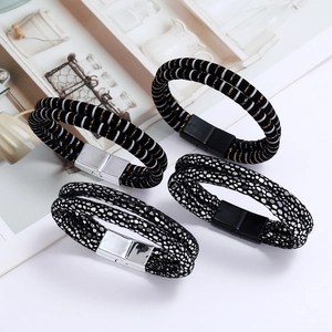 Detail of multi-layer leather bracelets featuring metal magnetic clasps and textured bands
