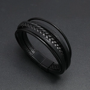 Detail of multi-layer black braided leather bracelet with magnetic metal clasp for men