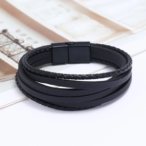 Détail d'un bracelet multicouche en cuir tressé noir avec fermoir magnétique noir mat