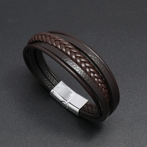 Detail view of multi-layer brown braided leather bracelet with silver magnetic clasp
