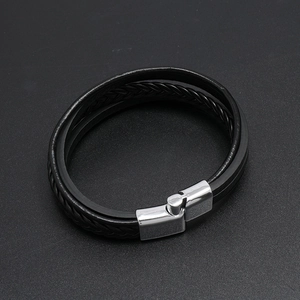 Detail of multi-layer black braided leather bracelet with silver magnetic metal clasp