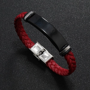 Detalle de pulsera de cuero trenzado rojo con cierre de acero y placa metálica negra