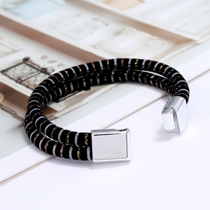 Close-up of double-layer woven cord bracelet with polished silver magnetic buckle