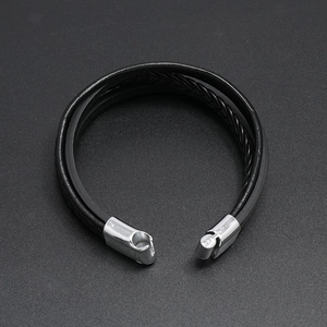 Detail of multi-layer black braided leather bracelet with silver magnetic metal clasp