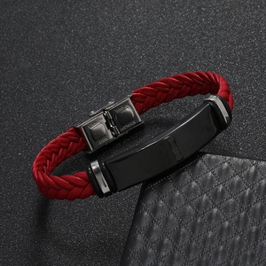 Detalle de la pulsera de cuero rojo trenzado con placa negra y cierre de acero inoxidable