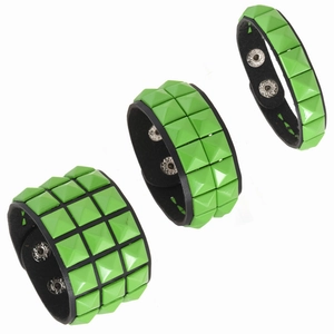 Drei Reihen neongrüner quadratischer Nieten auf schwarzen Punk-Lederarmbändern mit Druckknopf