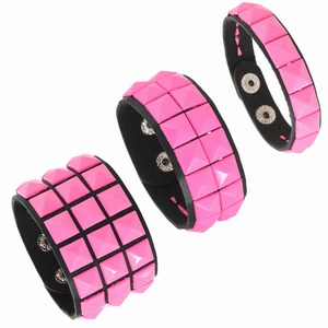Detail von pinkfarbenen Punk-Lederarmbändern mit ein-, zwei- und dreireihigen Nieten