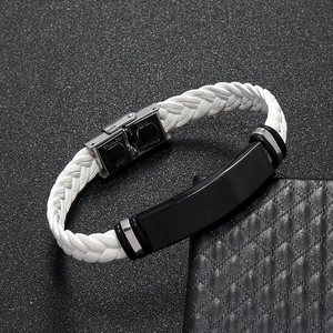 Detalle de pulsera de cuero trenzado blanco con placa de acero negro y cierre desplegable