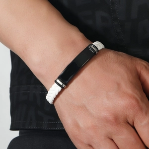 Detalle de pulsera trenzada blanca para hombre con placa de acero inoxidable negro mate