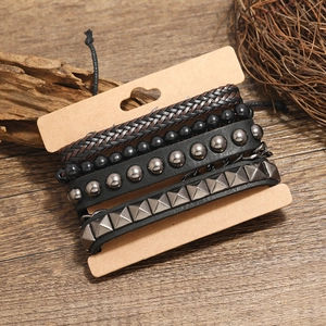 Retro braided leather bracelet set with beads and metal studs on wooden background