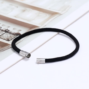 Dettaglio del bracciale in corda intrecciata nera con fibbia magnetica argento e trama