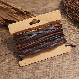 Detalle de pulseras de cuero multicapa con cuerdas trenzadas en tarjeta de papel vintage