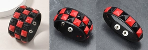 Details von Punk-Lederarmbändern mit roten und schwarzen quadratischen Nieten und Druckknöpfen