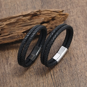 Detail eines mehrlagigen schwarzen Lederarmbands mit Magnetverschluss aus Metall auf Holz