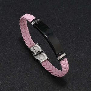 Detalle macro de la pulsera de cuero trenzado rosa con placa negra y cierre de acero