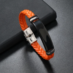 Detalle de pulsera de cuero trenzado naranja con hebilla de acero y placa de metal negro