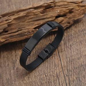 Pulsera minimalista de cuero negro y acero inoxidable sobre una superficie de madera