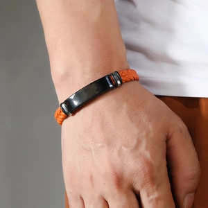 Primer plano de pulsera trenzada naranja para hombre con placa de metal negro