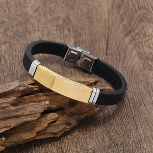 Men's leather braided bracelet with gold stainless steel plate on rustic wood background