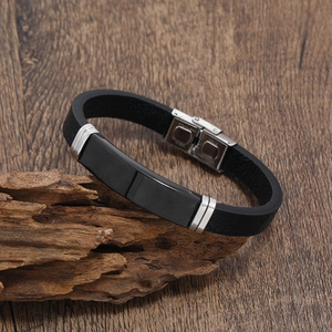 Men's black braided leather bracelet with stainless steel plate on rustic wood base