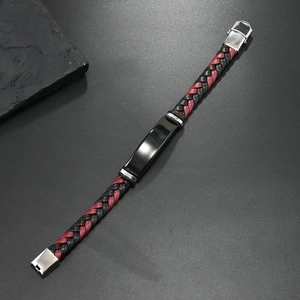 Detalle de la pulsera de cuero trenzado rojo y negro con placa de metal pulido