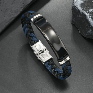 Detalle de pulsera de cuero trenzado para hombre con placa de metal negro y cierre de acero
