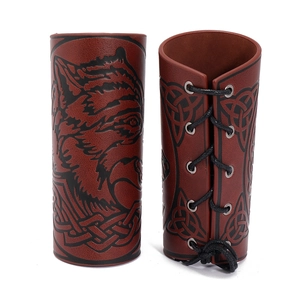 Detail of brown PU leather arm guards featuring a wolf head print and black lace-up closure