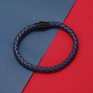 Détail du bracelet en cuir tressé bleu marine avec fermoir de sécurité noir sur rouge