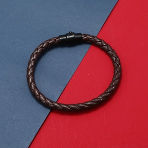 Détail du bracelet en cuir tressé marron foncé avec fermoir en métal noir élégant