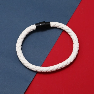 Gros plan sur bracelet en cuir tressé blanc avec fermoir magnétique noir sur fond bicolore