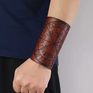 Macro shot of brown leather arm guard featuring Nordic Vegvisir compass and runic embossing