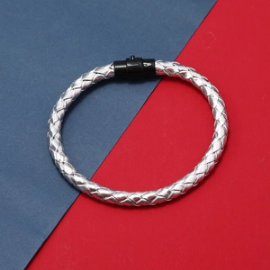 Détail du bracelet tressé en cuir avec fermoir magnétique noir sur fond bicolore vif