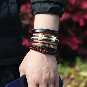 Multi-layer men's leather bracelet set with woven cords and bronze beads on a wrist