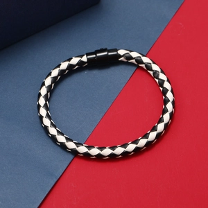 Détail du bracelet tressé en cuir noir et blanc avec boucle magnétique noire mate