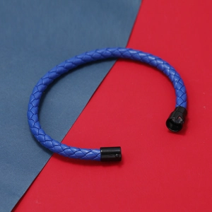 Détail de la texture en cuir tressé bleu et du fermoir de sécurité noir du bracelet pour homme