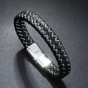 Detailed close-up of men's black woven leather bracelet with polished steel magnetic clasp