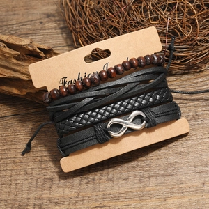 Vintage 4-piece men's leather bracelet set with infinity symbol on wooden background